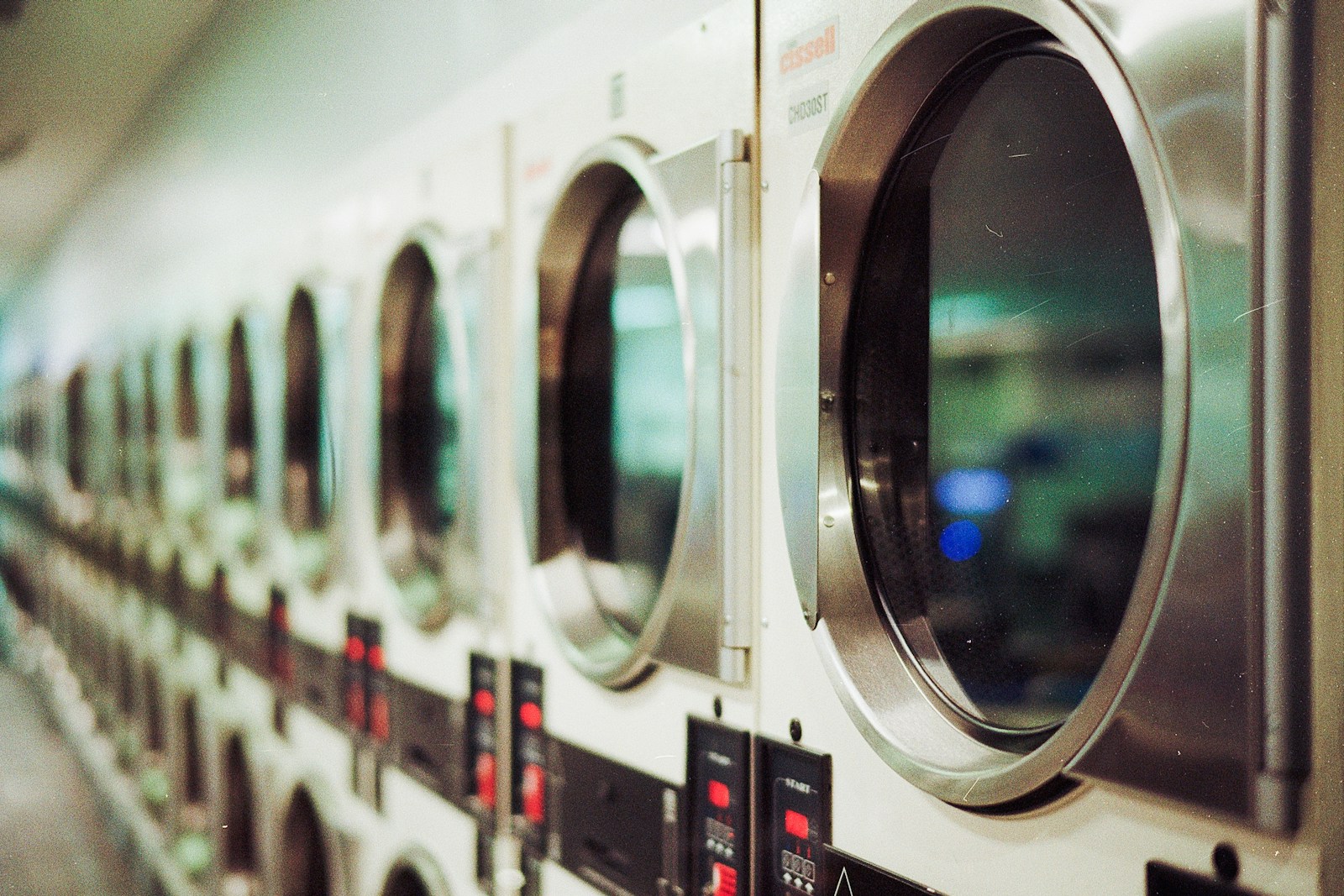 Deretan mesin cuci dan pengering di tempat laundry yang bersih