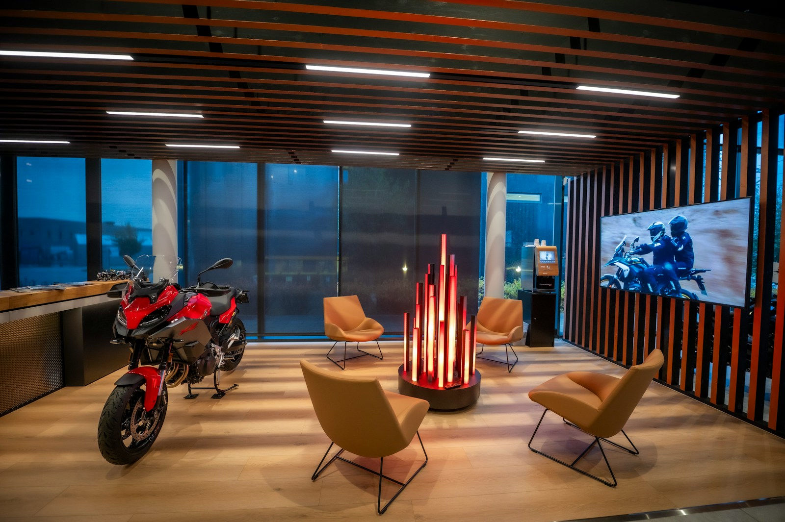 Ruang pamer dealer motor modern dengan sofa tunggu dan satu unit motor