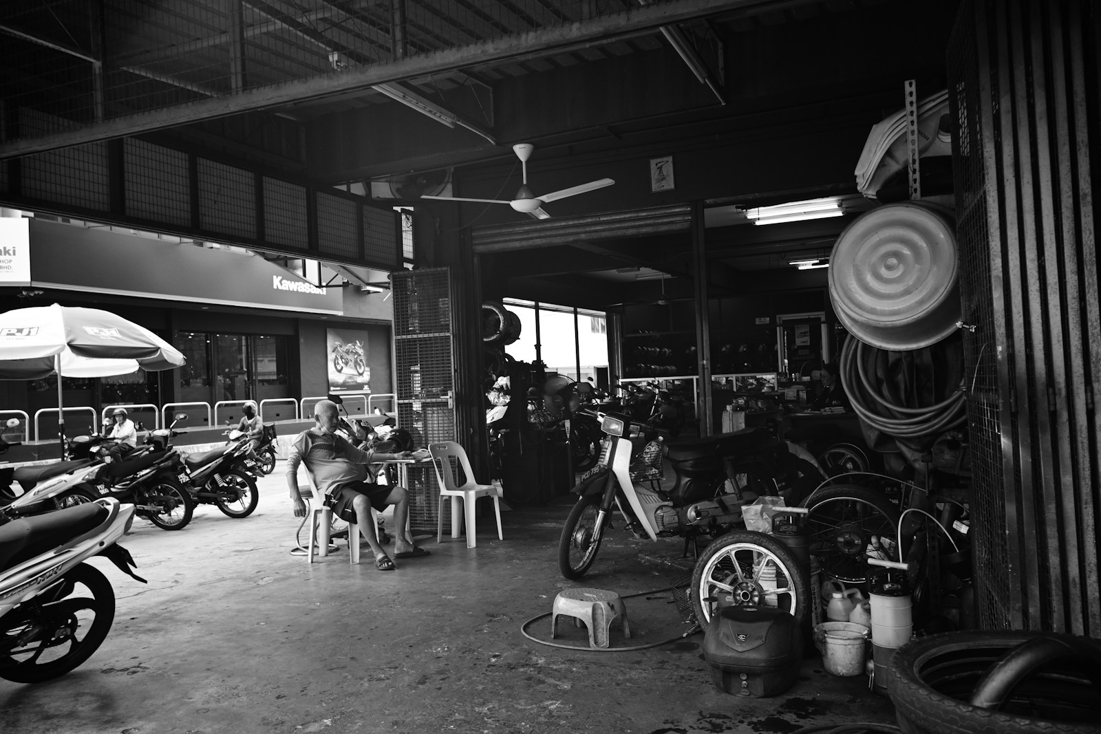 Bengkel dealer motor dengan deretan motor bebek dan suku cadang
