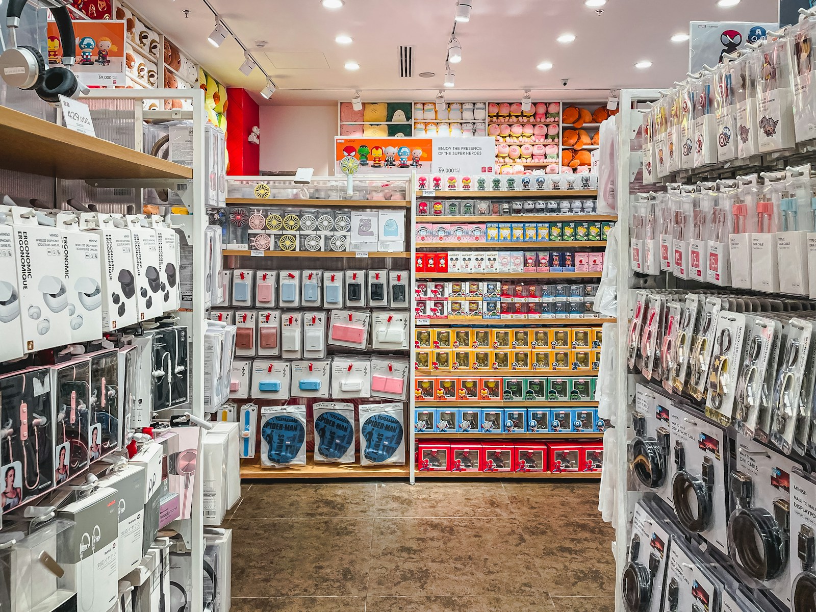 Rak toko berisi aneka aksesori elektronik seperti earphone, powerbank, dan kabel