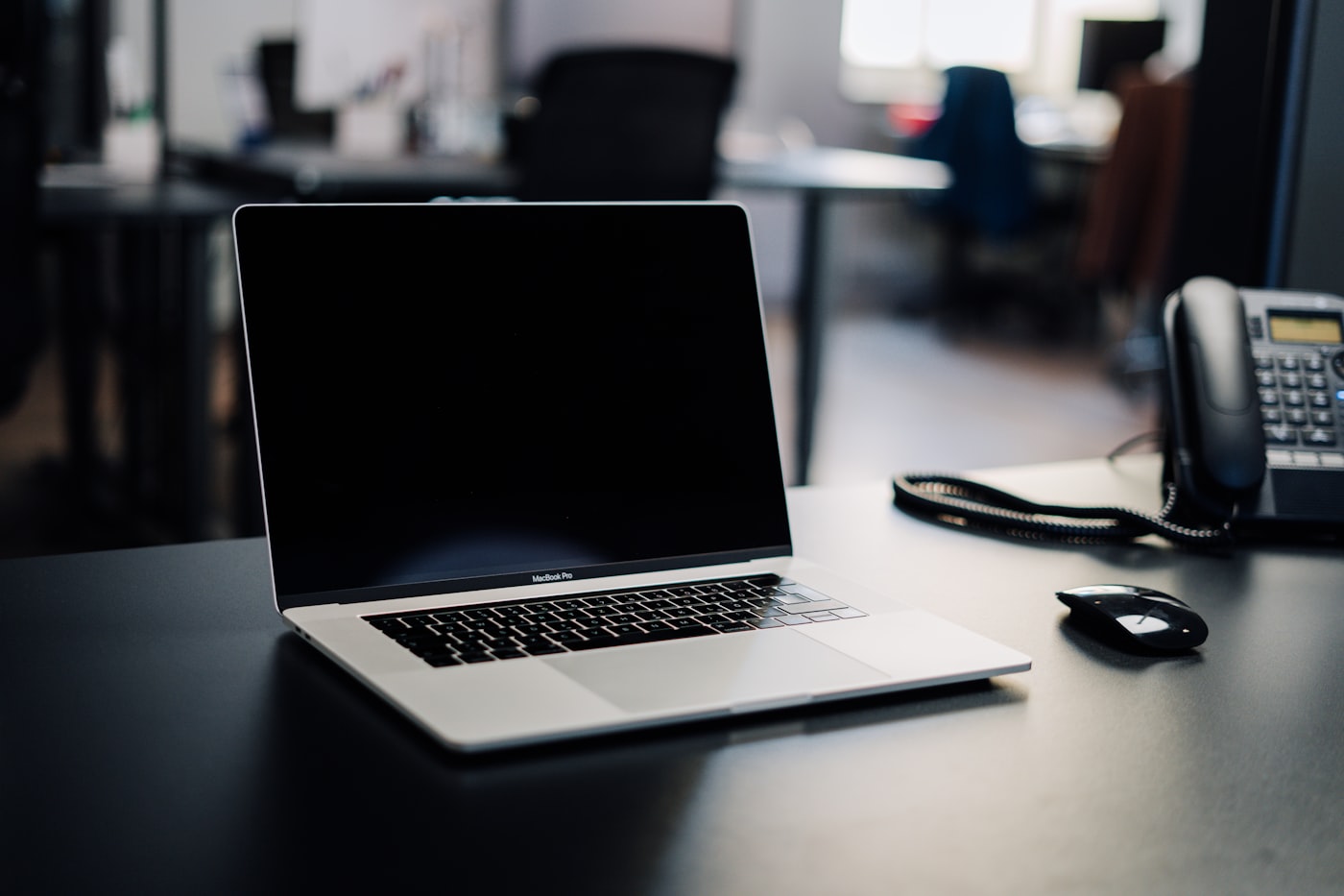 Laptop dan telepon kantor di atas meja