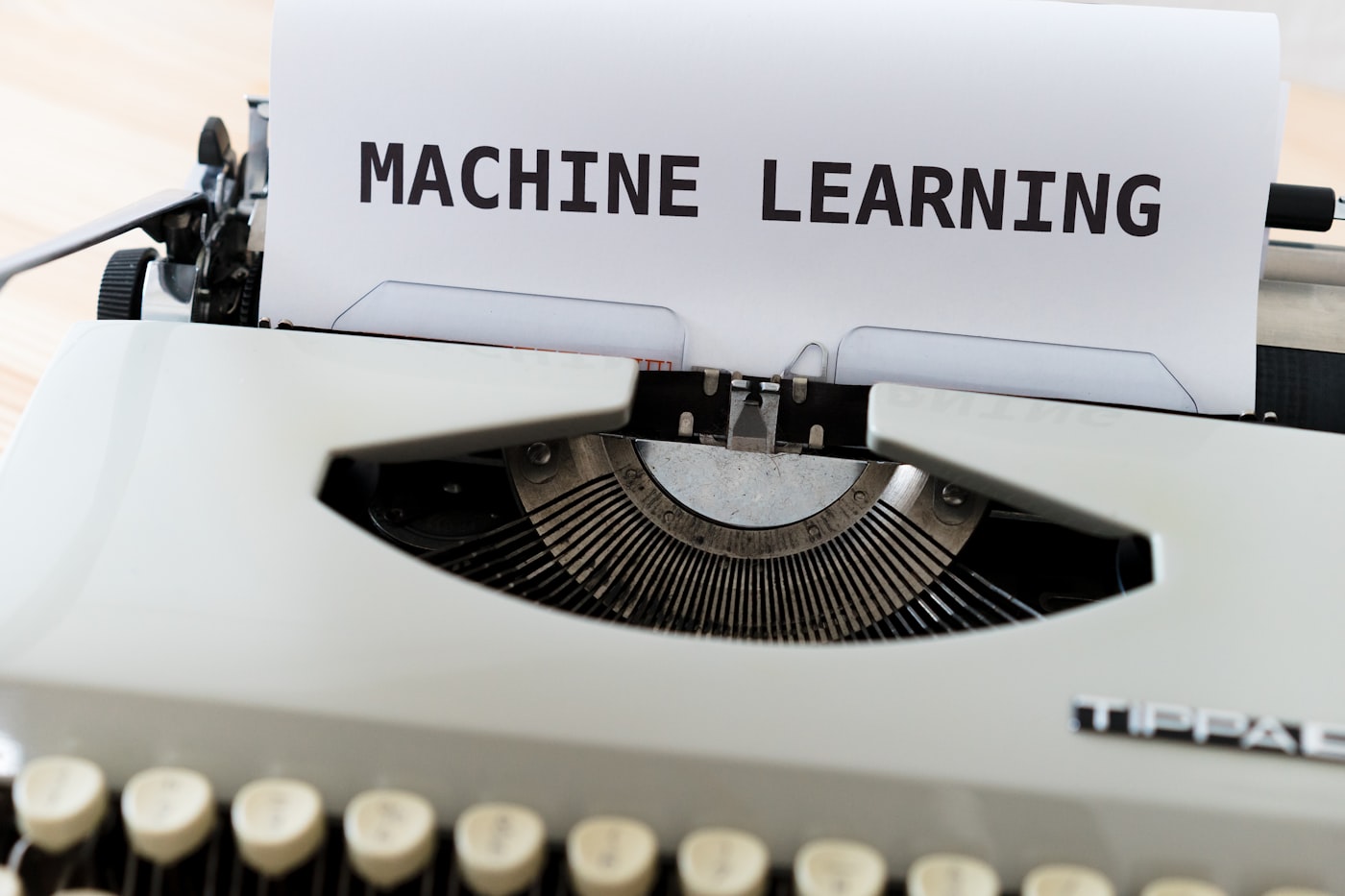 Mesin tik dengan kertas bertuliskan machine learning