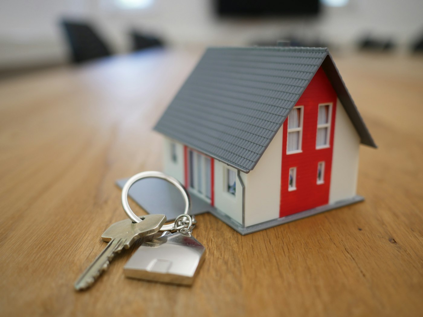 Miniatur rumah dengan kunci di sampingnya