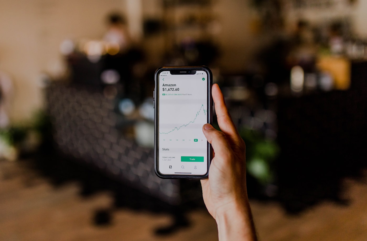 Tangan memegang ponsel menampilkan aplikasi chat